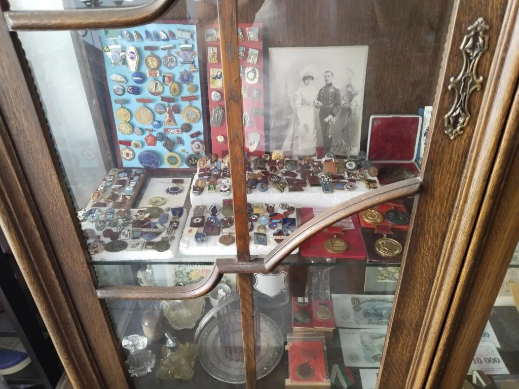 A cabinet displaying a collection of vintage badges and medals at Karesa Antiques Shop in Varna.