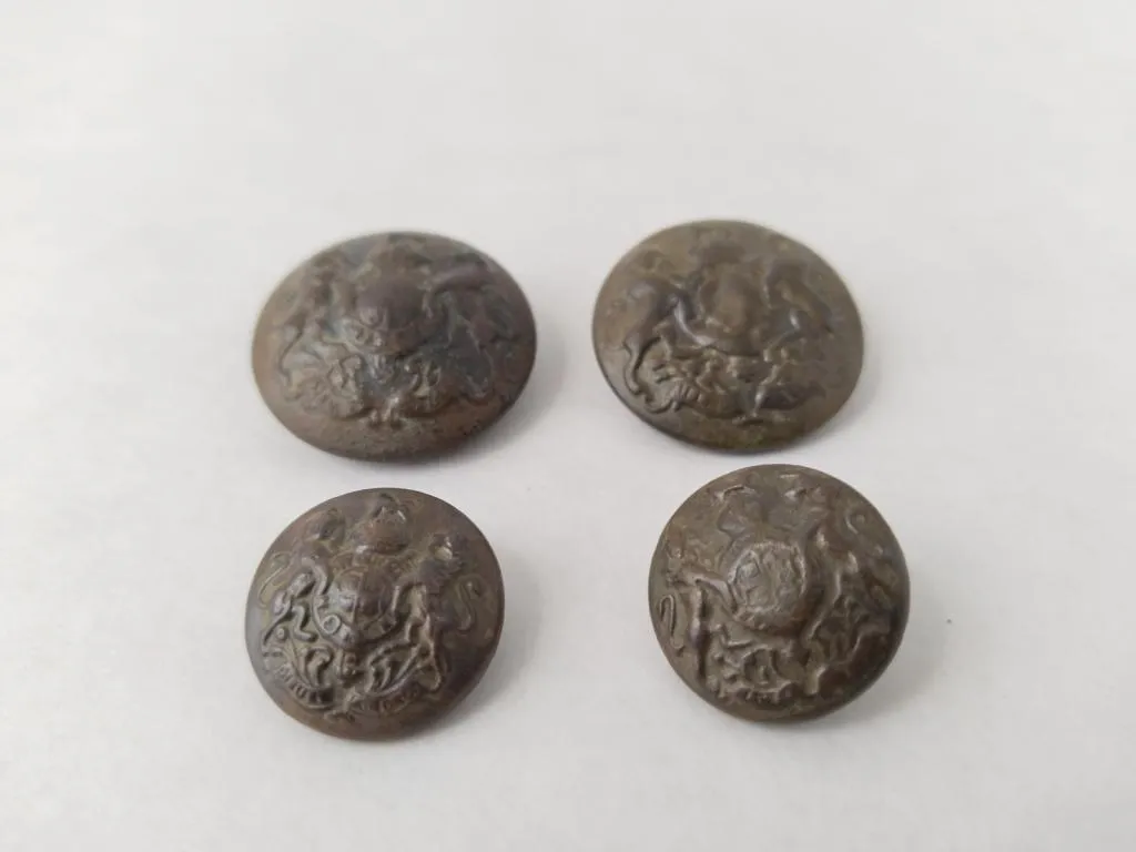 A set of four British military buttons from World War I, featuring the British Royal Coat of Arms.