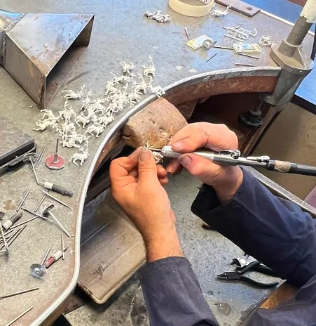 A craftsman cutting and grinding at the counter in the Saturno 182 AR laboratory