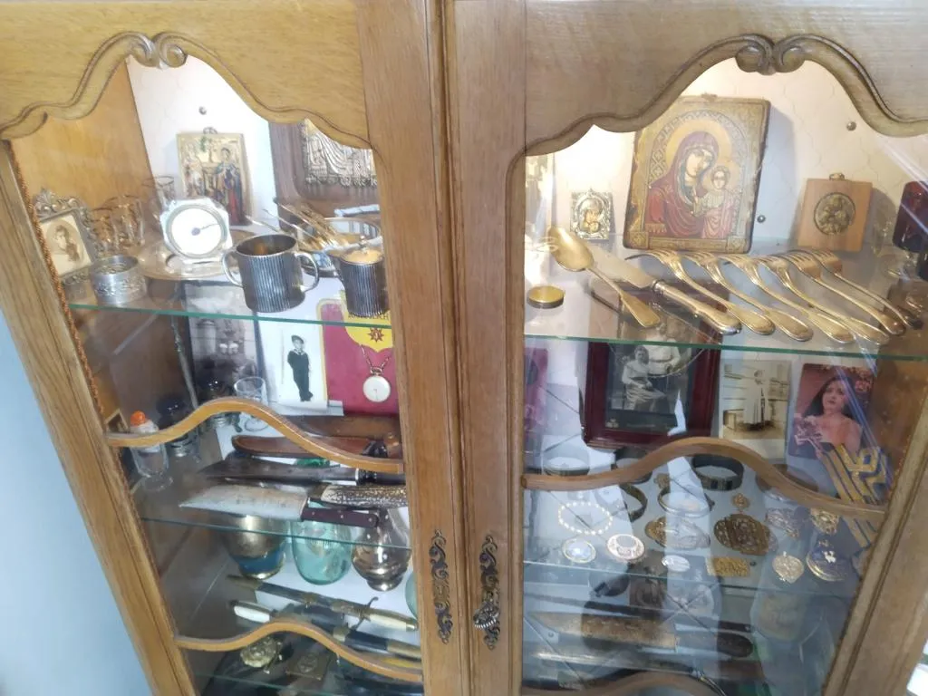 A cabinet showcasing militaria, antique jewelry, and religious icons at Karesa Antiques Shop in Varna.