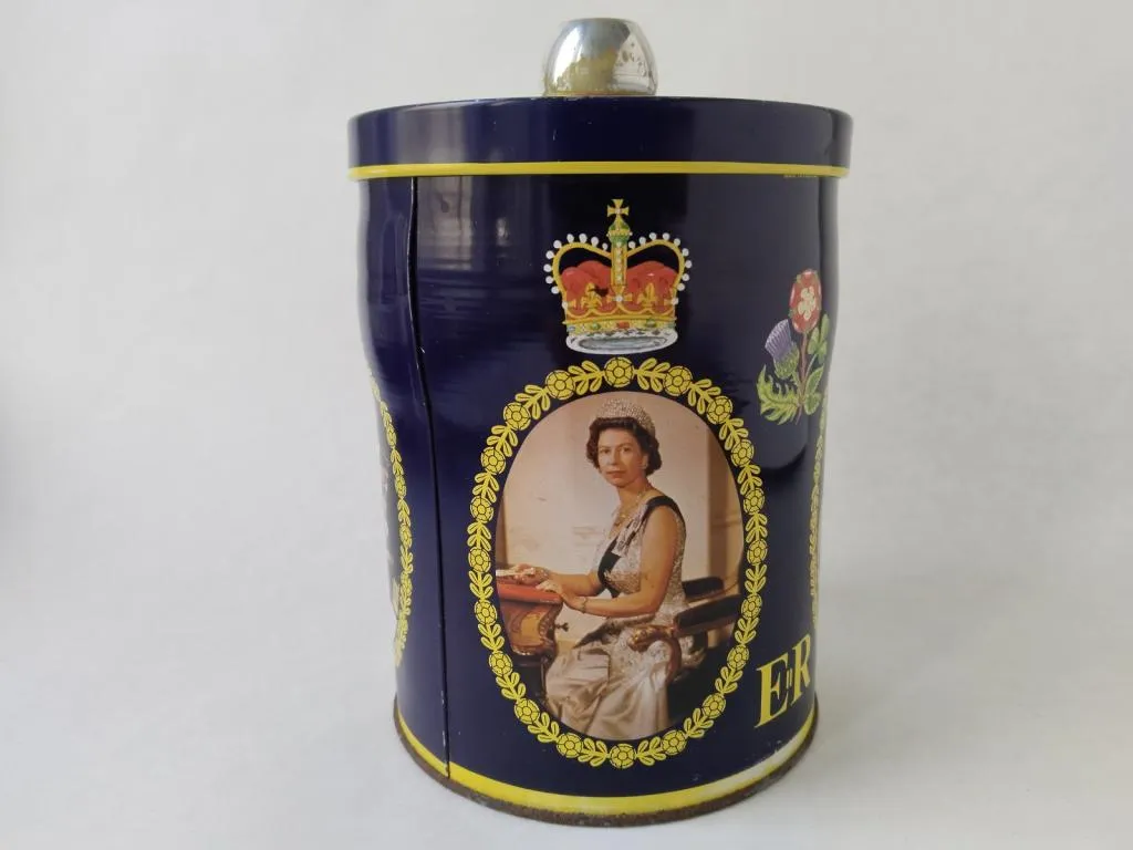 The Queen Elizabeth II Silver Jubilee Tin Box from 1977, features images of Her Majesty and commemorating the 25th anniversary of her reign.