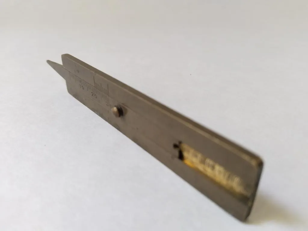 A retro Continental tire tread depth gauge made of brass, likely from the early 2000s, used to measure tire wear with precision.