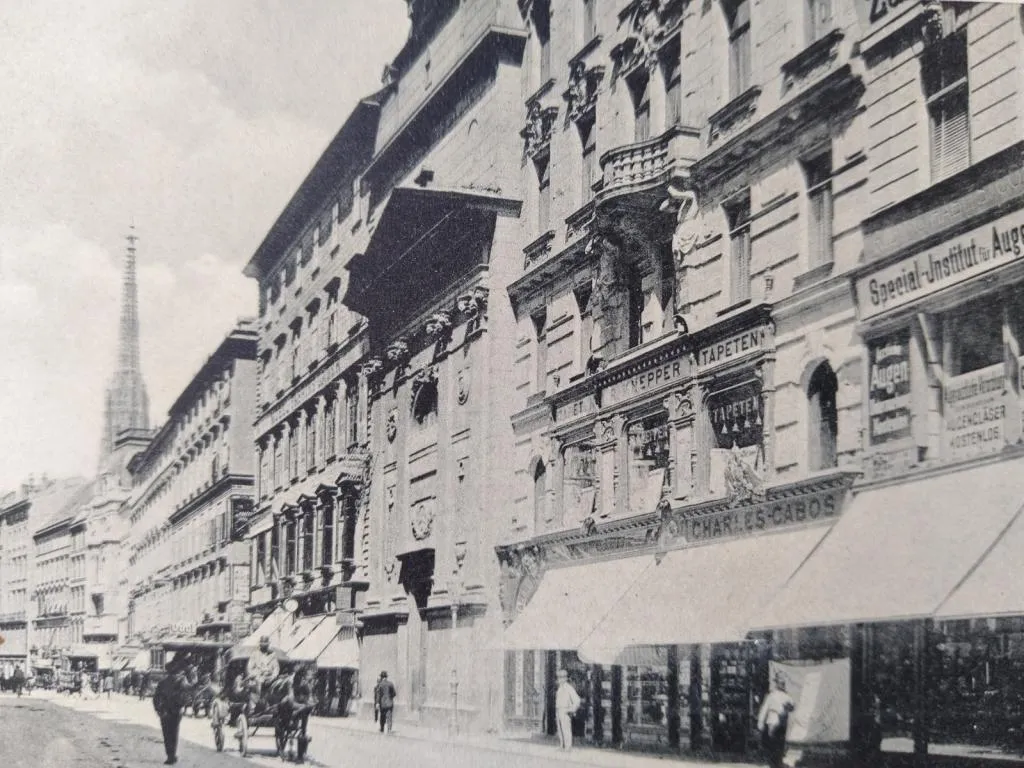 Eine historische Ansichtskarte aus dem Jahr 1900, die den Standort von Milkovits & Cie in der Kärntnerstraße 21 hervorhebt und die Pracht des Wiener Luxusviertels dieser Zeit einfängt.