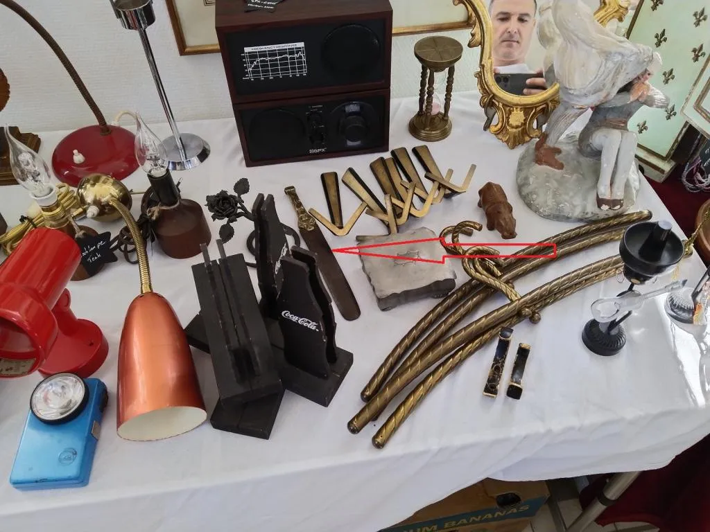 A dealer’s table at the Vintage Market Vienna, featuring various vintage items. Highlighted with a red arrow is the Rococo-style knife polisher.