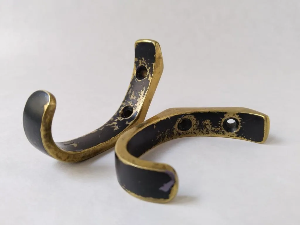 A pair of vintage Walter Bosse coat hooks in brass with black lacquer, showcasing his timeless mid-century design.